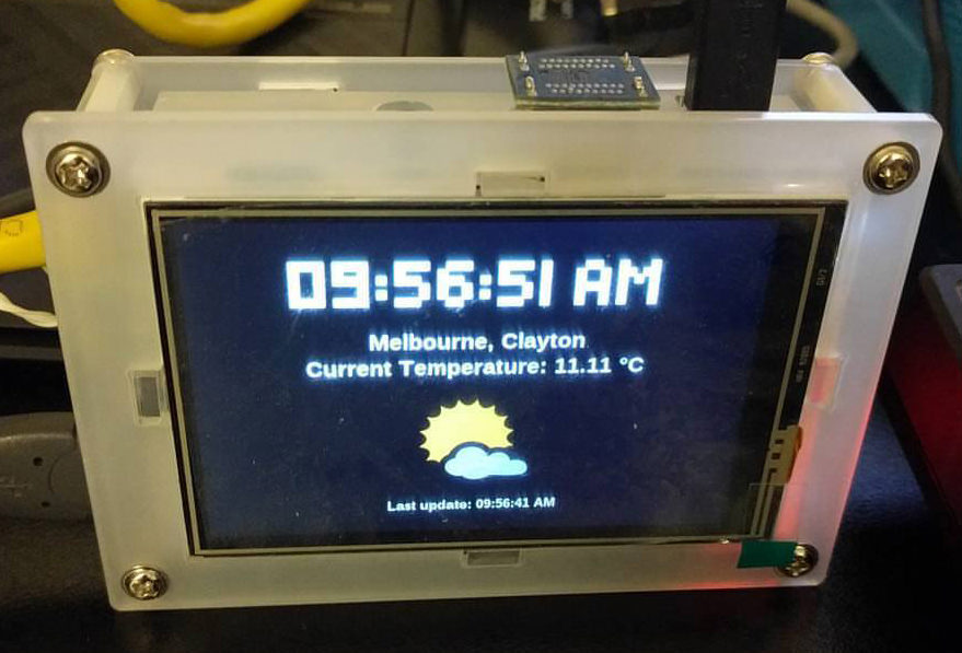 WeatherPi running on a Raspberry Pi screen in a clear acrylic case, showing the time, location and current temperature